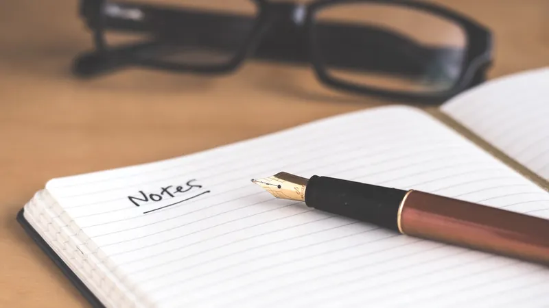 Notebook with handwritten meeting notes and pen on desk, a delivery lead's working notes from a discovery session